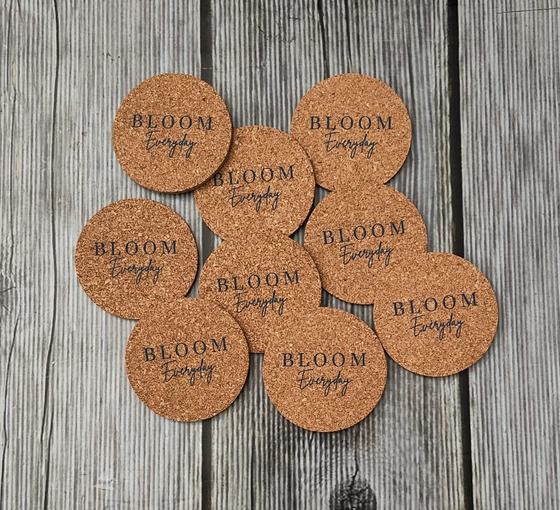 Close up of nine cork coasters with engraved script lettering, custom made by RestroCart, New Delhi