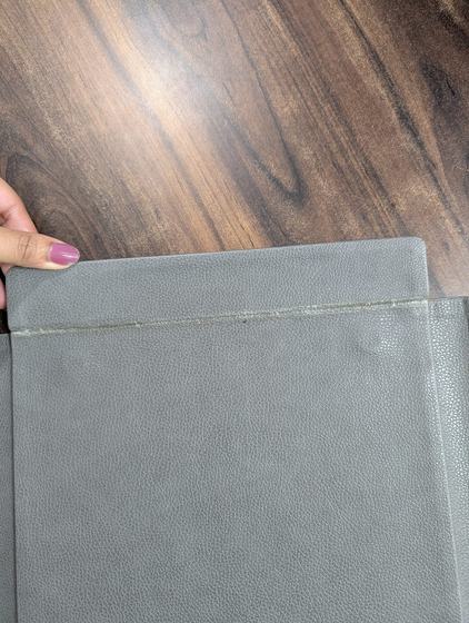 Grey leatherette menu folder edge held in hand, close-up, custom made by RestroCart, New Delhi