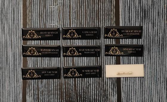 Black and gold name badges with printed names, pin back shown, custom made by RestroCart, New Delhi