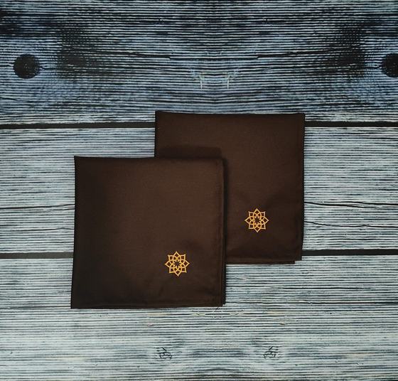 Brown table napkins with orange embroidered motif, folded pair, custom made by RestroCart, New Delhi